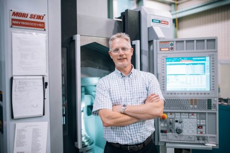 Stephen Veldhuis in front of equipment at the McMaster Manufacturing Research Institute