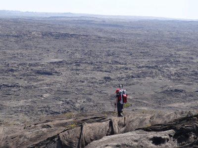 One researcher on a wide, rocky landscape