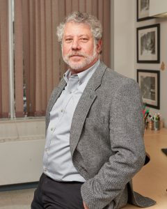 Professor Benson Honig standing in front of a desk with his hands in his pockets. 