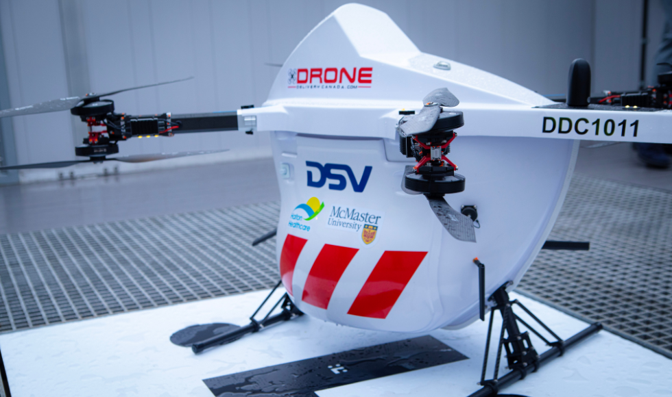 A drone with the logos for McMaster, Halton Healthcare and DSV Canada