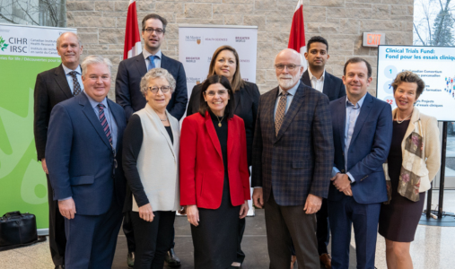 A group photo of seven researchers, university president David Farrar, MP Filomena Tassi and CIHR president Strong.