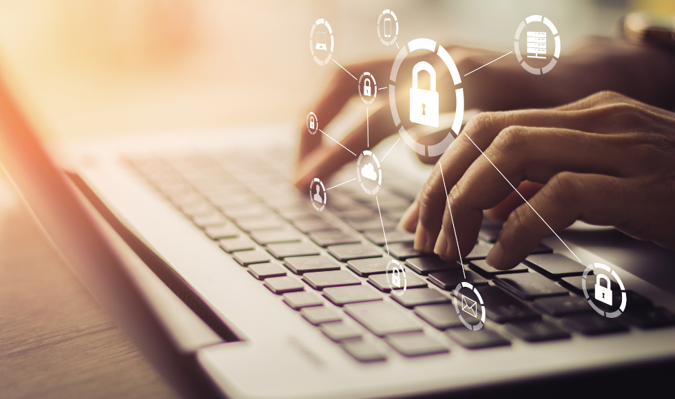 Hands typing on a laptop. Over the hands there are a variety of white graphic symbols, including an envelope, a closed lock and cellphone.