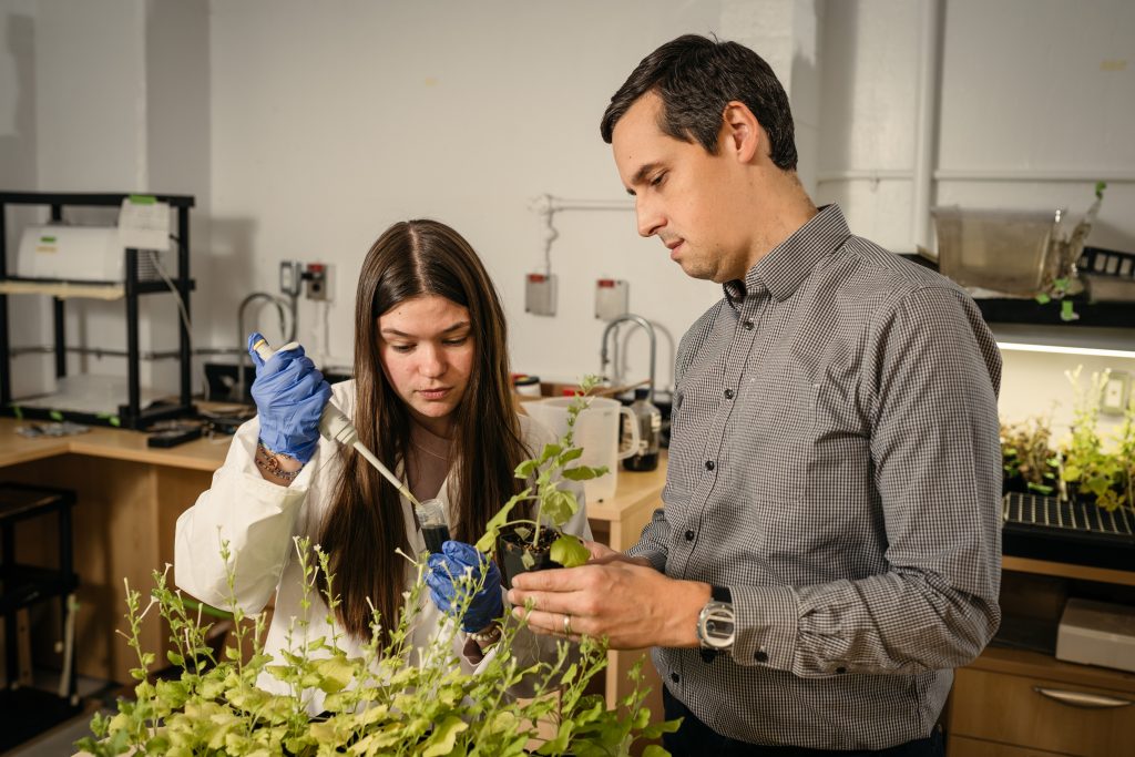 Todd Hoare and a student pose with plants.