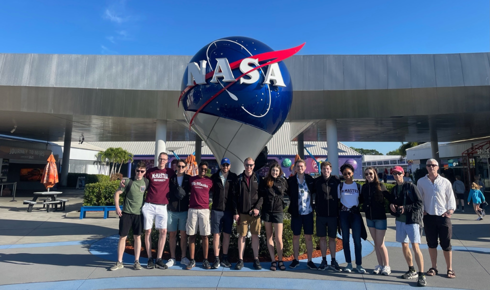 A team photo in front of a NASA sign at the Kennedy Space Center.