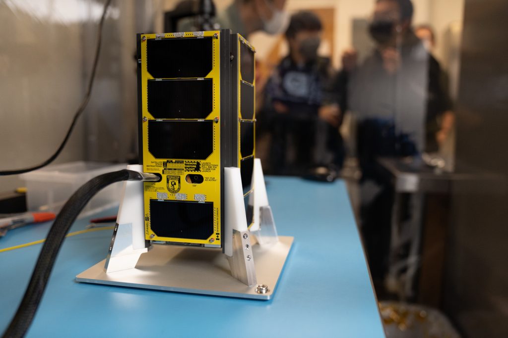 The NEUDOSE Satellite sitting on a table in a lab.