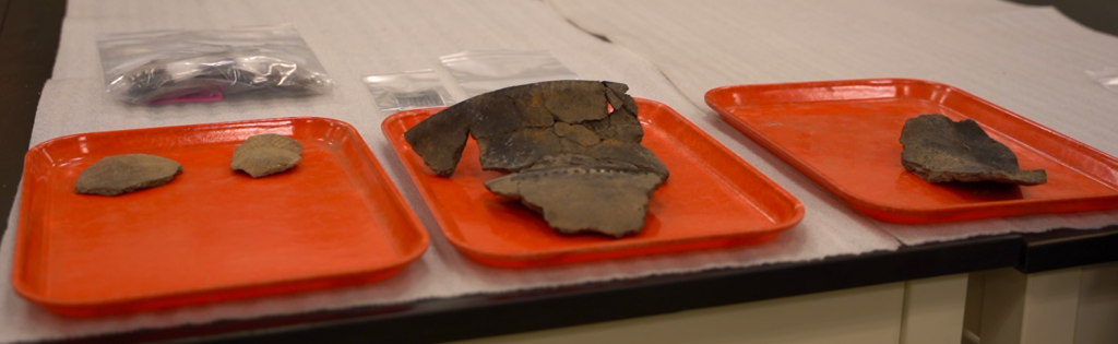 Pieces of broken pottery on orange trays on a table