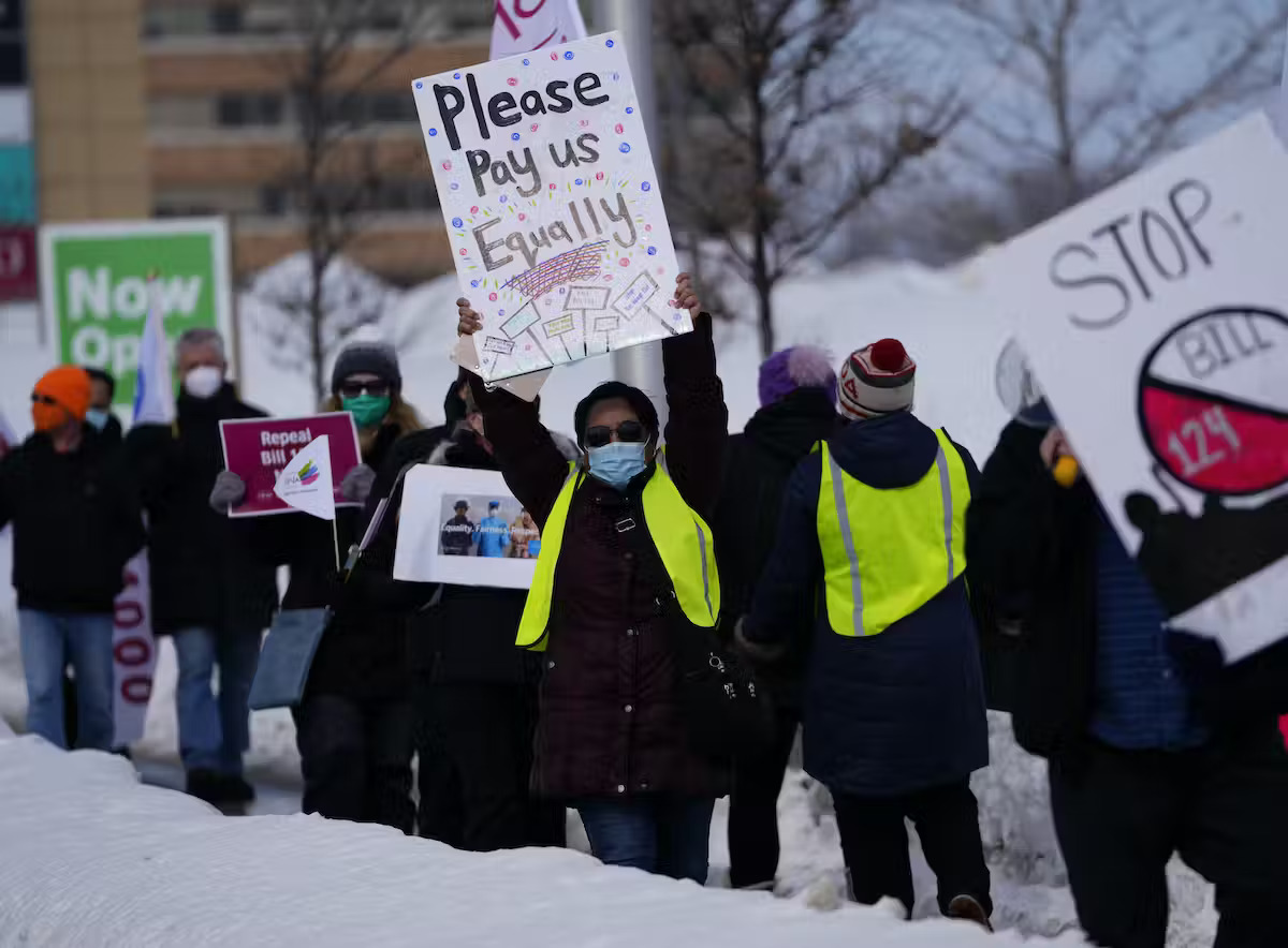 People protesting and holding up signs outdoors during winter