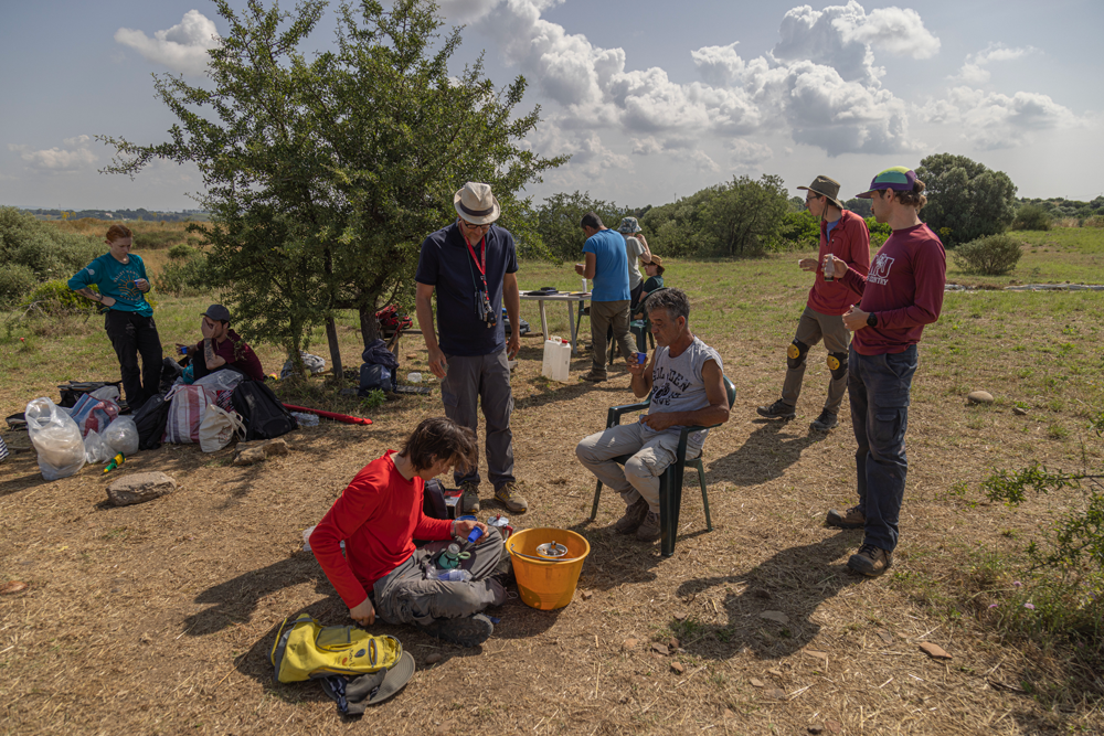 A photo of 10 members of the Metaponto dig enjoying a coffee break in the shade of a nearby tree.