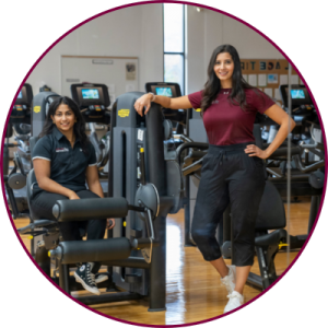 Two women standing inside a gym 