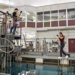 Two employees of the McMaster Nuclear Reactor conduct research in the nuclear pool.