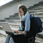 A student sits outside on her laptop.