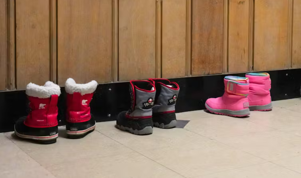Three pairs of children's winter boots lined up against a wall.