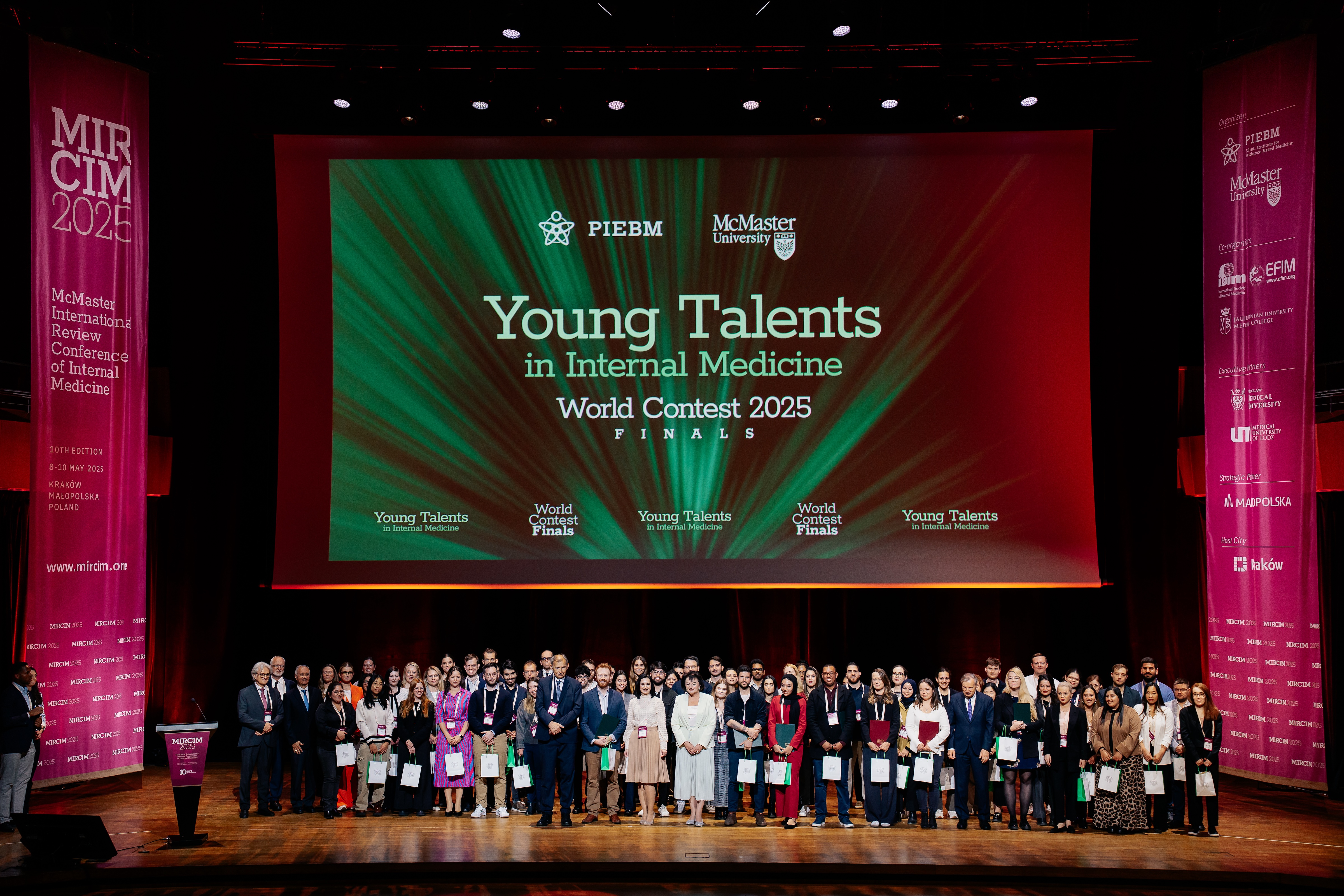 A large group of young medical practitioners standing on a stage under a screen that reads Young Talent