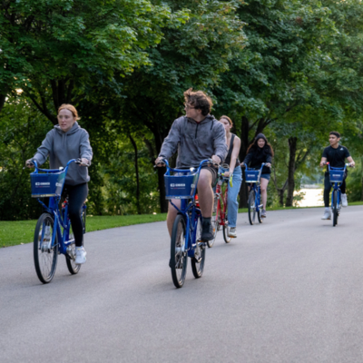 A group of students cycling along a paved trail.