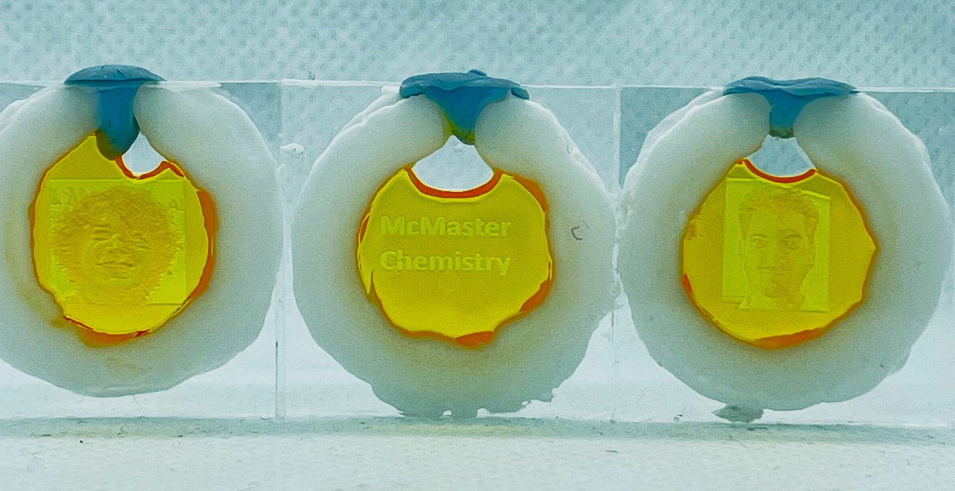 Three medals that say 'McMaster chemistry.' 