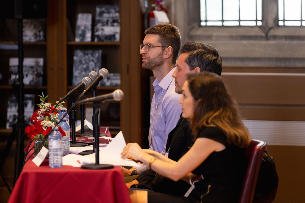 Three people sit at a judges' table