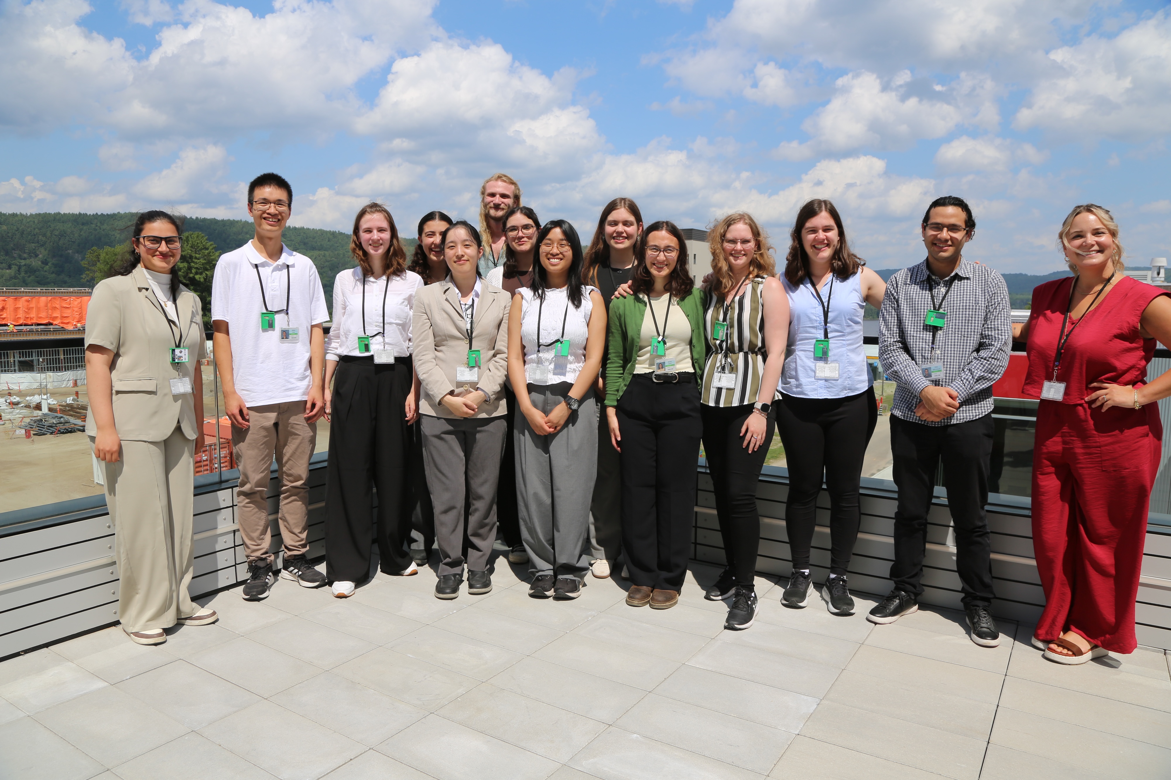 A group shot of about fifteen people, standing on a concrete balcony. 