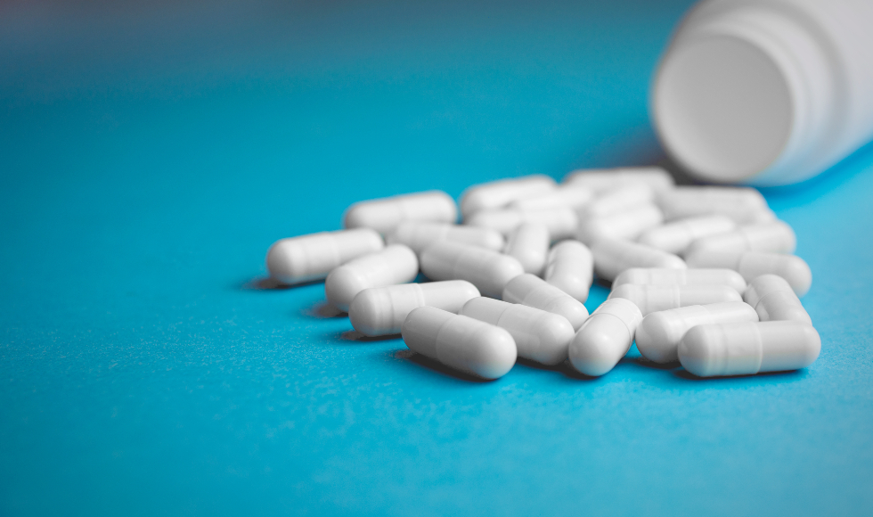 Photo of white pills on blue background