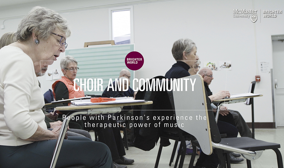 A group of older people sit in a music classroom singing