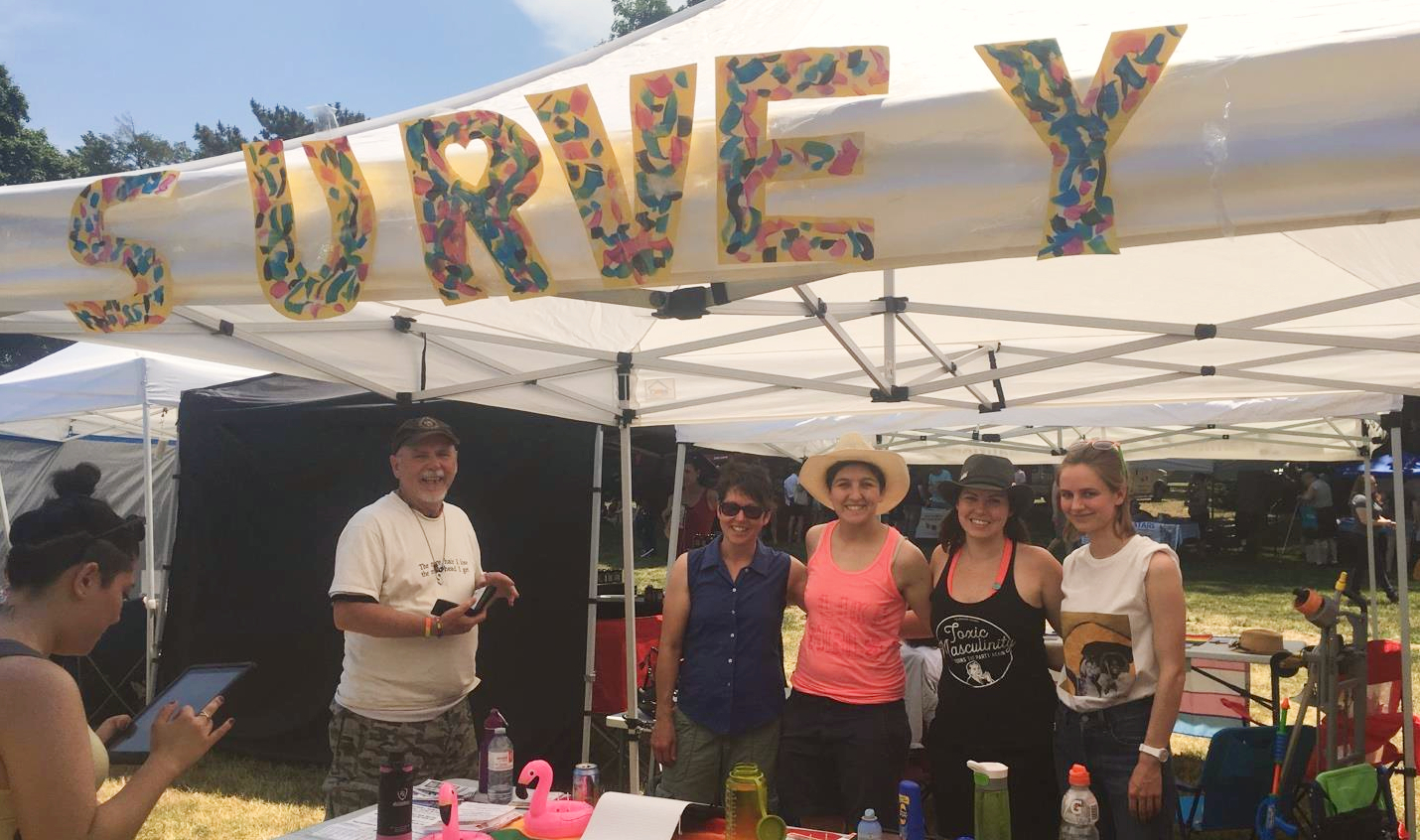 canvas tent at a festival with giant letters spelling out "survey" from 2018 Hamilton Pride festival.