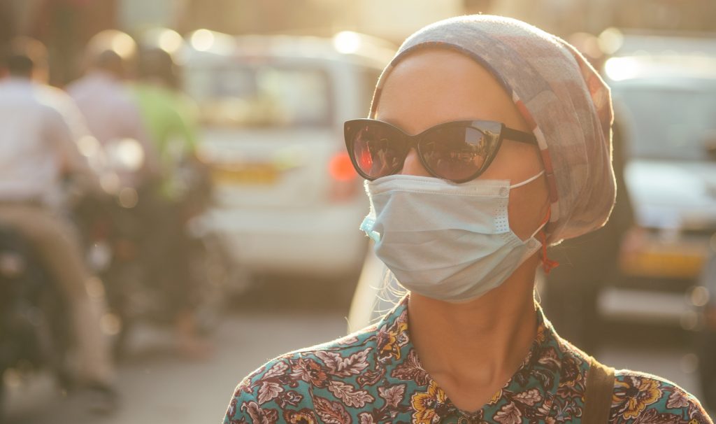 Stock image of women wearing a surgical mask outdoors