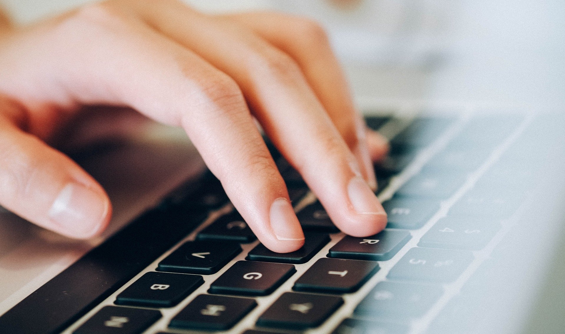 stock image of fingers typing on a computer keyboard