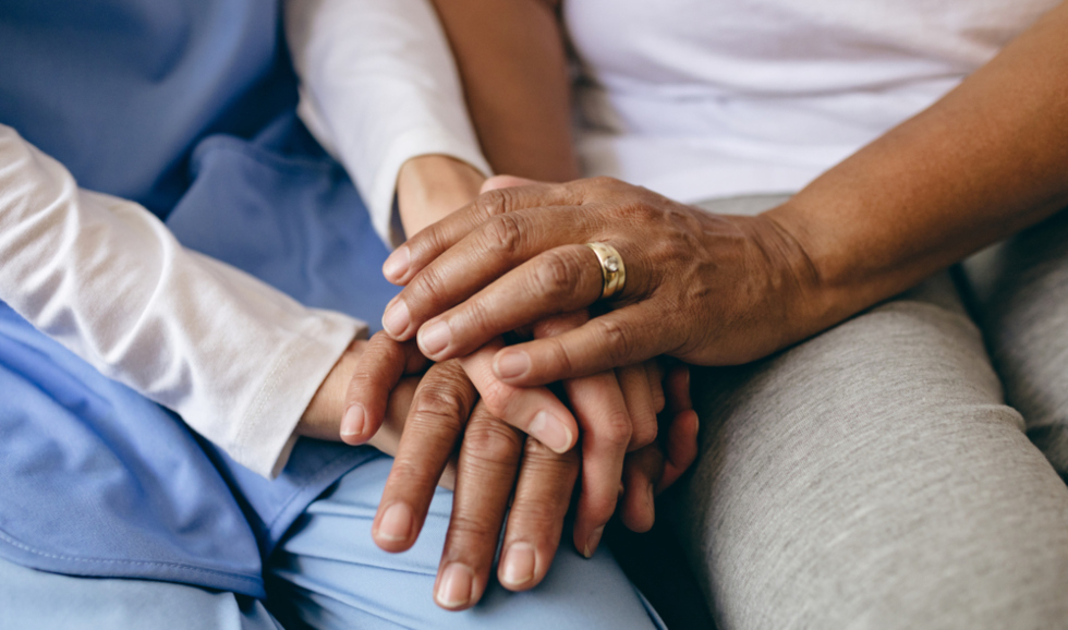 lose up of an older person's hands holding a younger person's hands