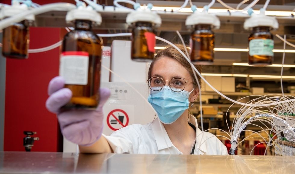 Person wearing gloves and a mask in a chemistry lab