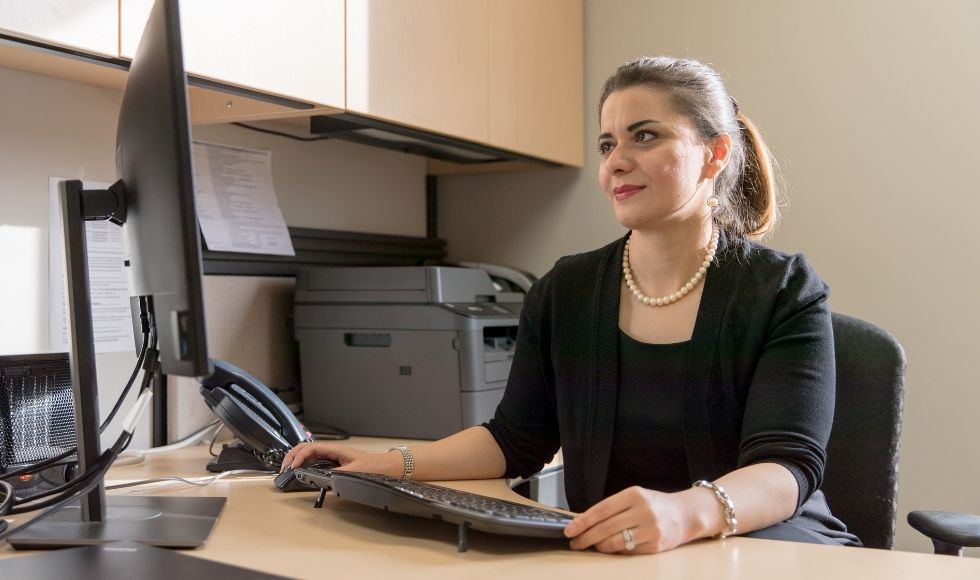 A woman sitting at a computer desk.