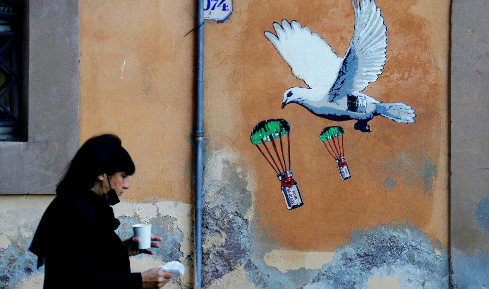 woman walking by a mural.