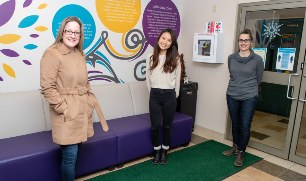 A photo of Melissa Kimber, Haruka Kanai and Louise Murray-Leung at the Lynwood Charlton Centre in Hamilton. The three women are standing apart from one another and smiling at the camera.