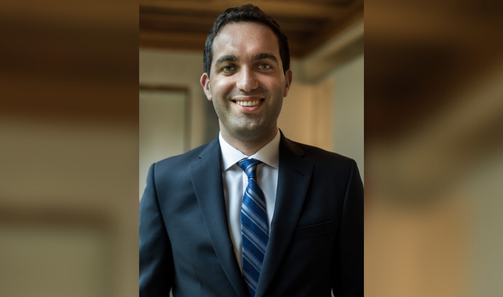 Head and shoulders of a smiling man in a suit