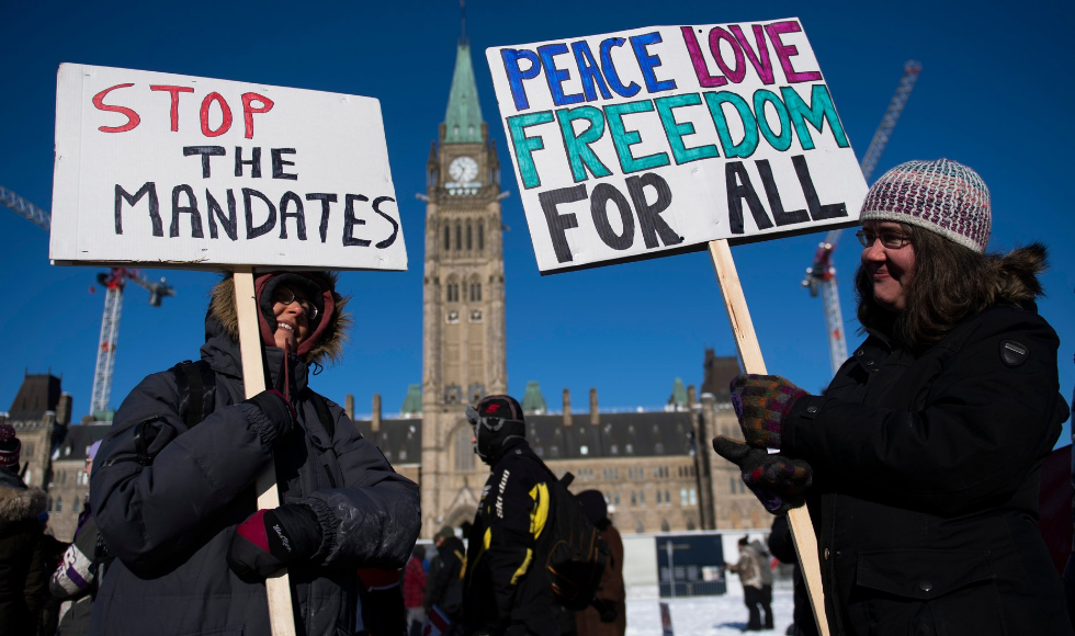 Protesters outside the Centre block of Parliament,carrying signs against vaccine mandates.