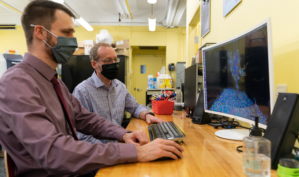 Sebastian Himbert and Maikel Rheinstadter sitting together in front of a computer screen