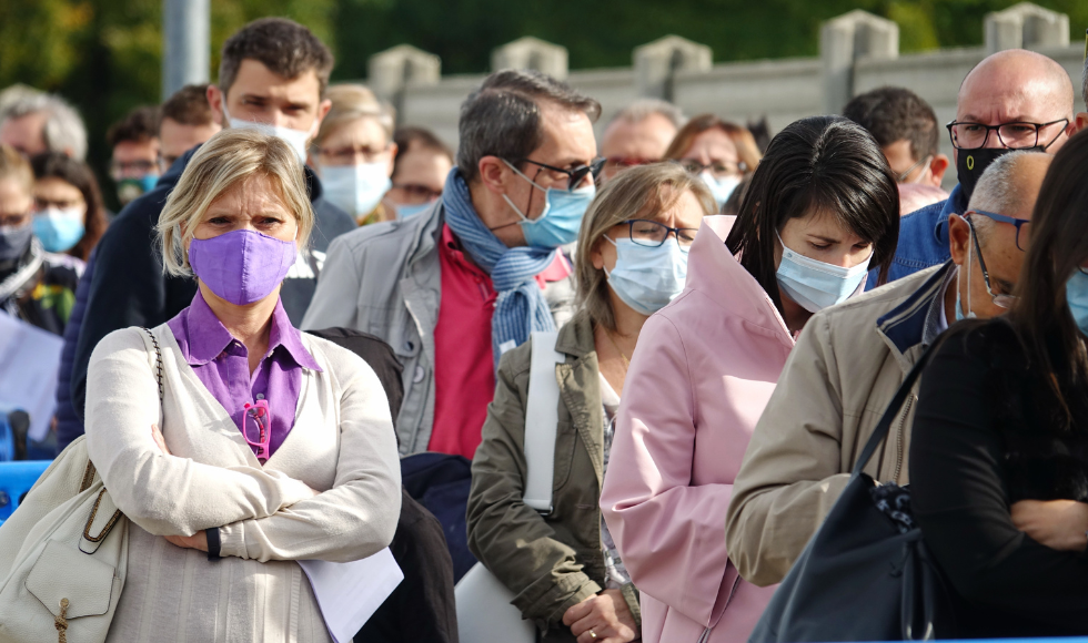A crowded lineup of people wearing masks