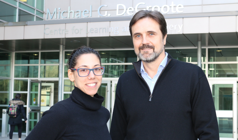Giada De Palma and Premysl Bercik posing for a photo in front of the Michael G. DeGroote Centre for Learning and Discovery