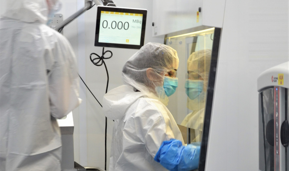 A McMaster University isotope production technician working inside a lab