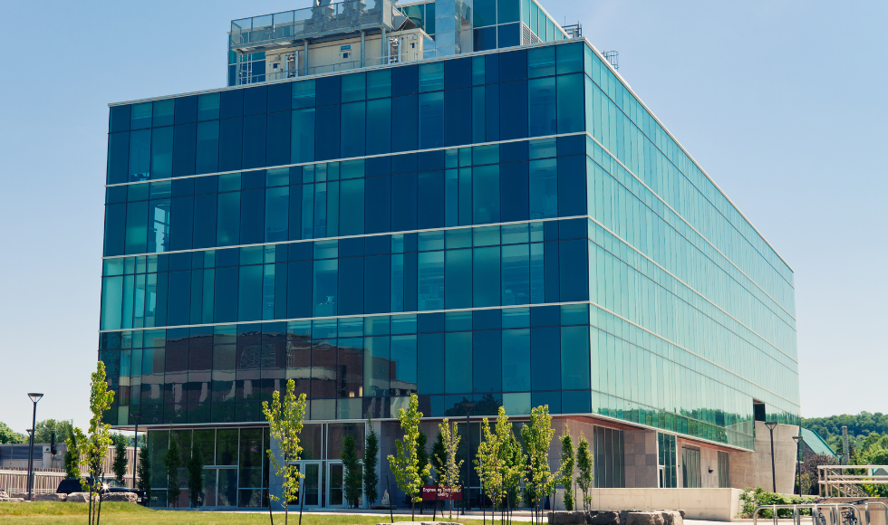 Exterior of the Engineering Technology Building, a big glass-sided building, on a sunny clear day.