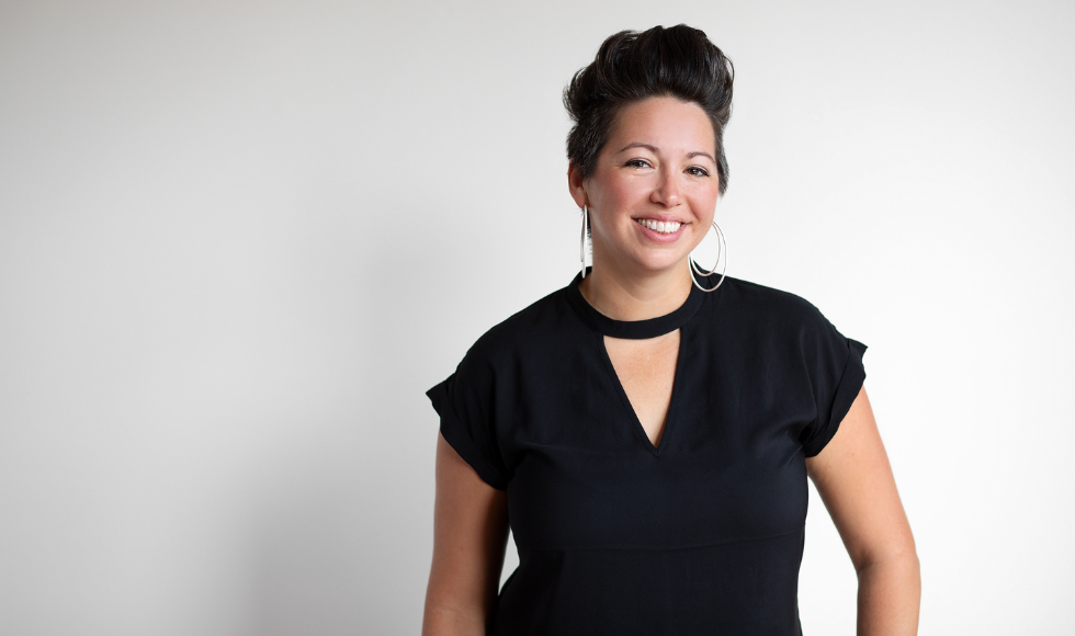 Waist-up portrait of smiling Lyndsey Beutin in a black shirt.