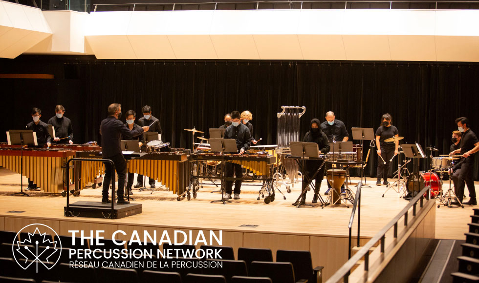 A percussion ensemble performing on a stage.