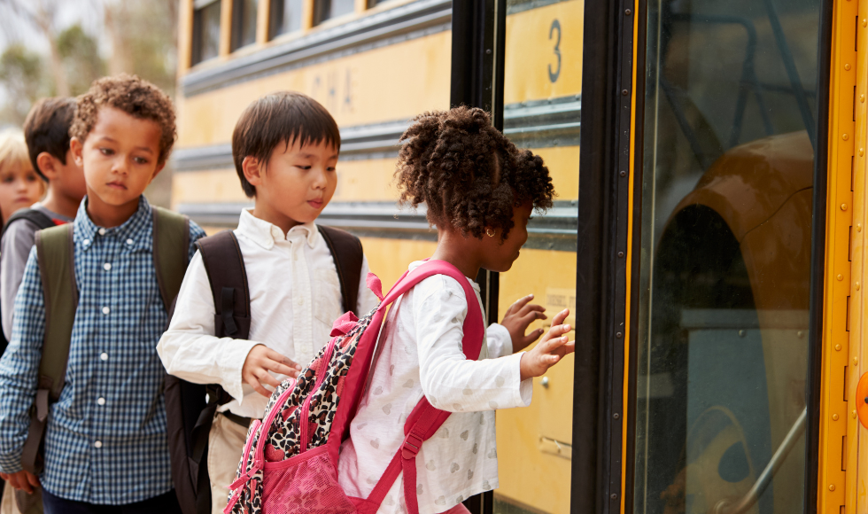 Children getting on to a yellow school bus