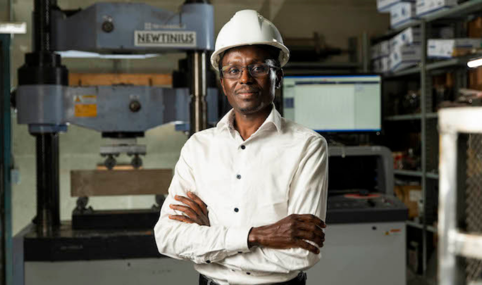 Ousmane Hisseine wearing a hard hat, smiling with his arms crossed.