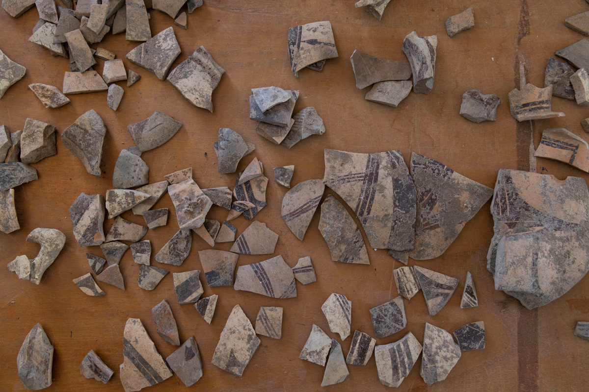 Sherds of pottery found at the Metaponto dig site laid out on a table.