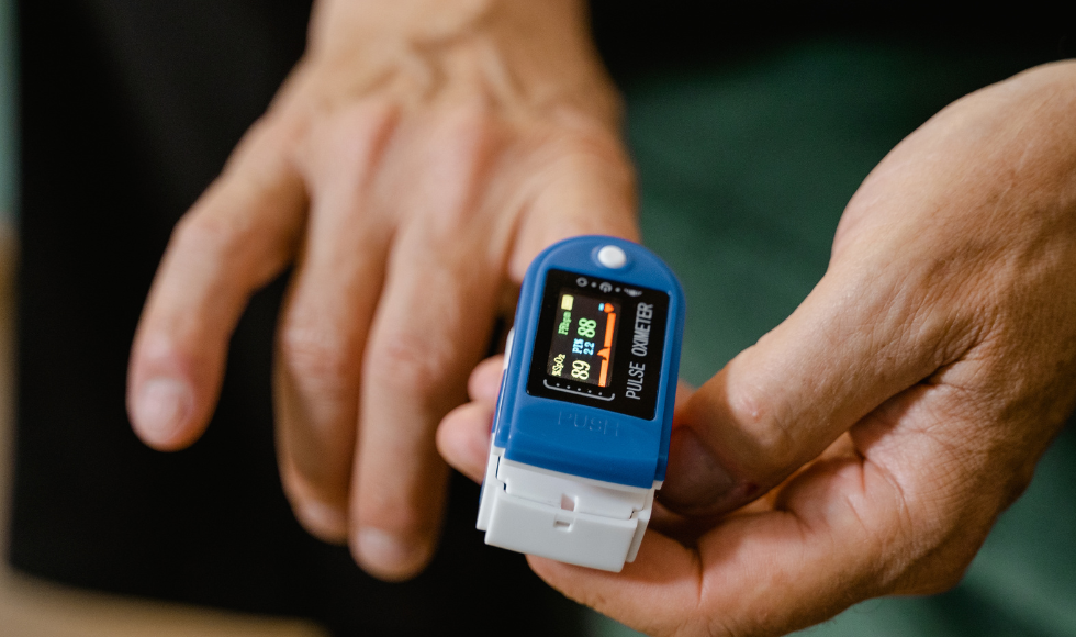 A pulse oximeter on a person's hand.