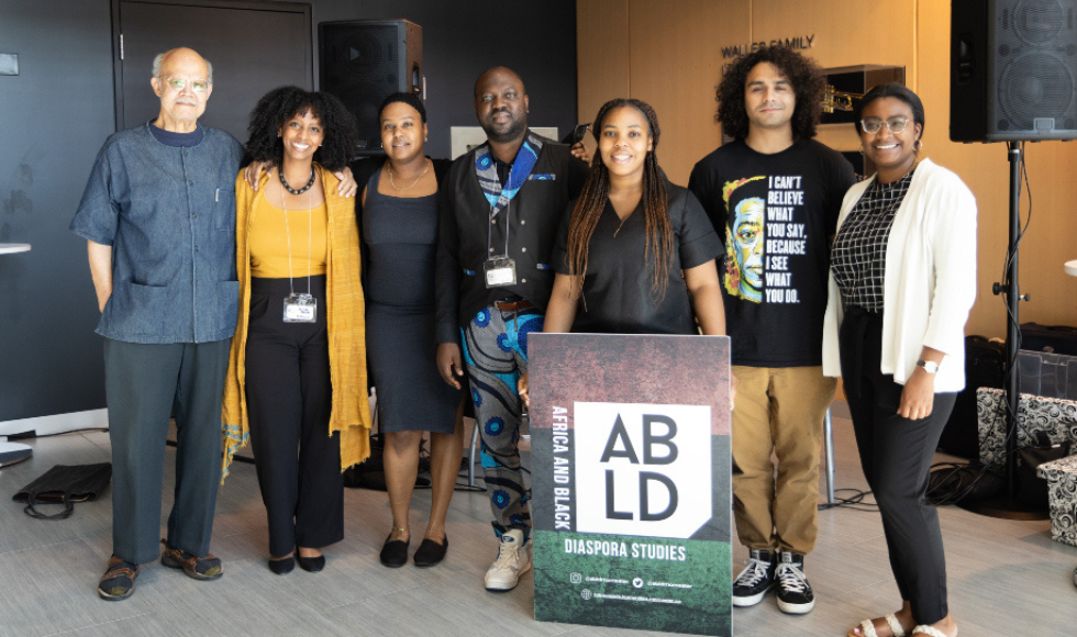 Seven people standing and looking directly at the camera. One person is holding a sign that reads ABLD Africa and Black Diaspora Studies.