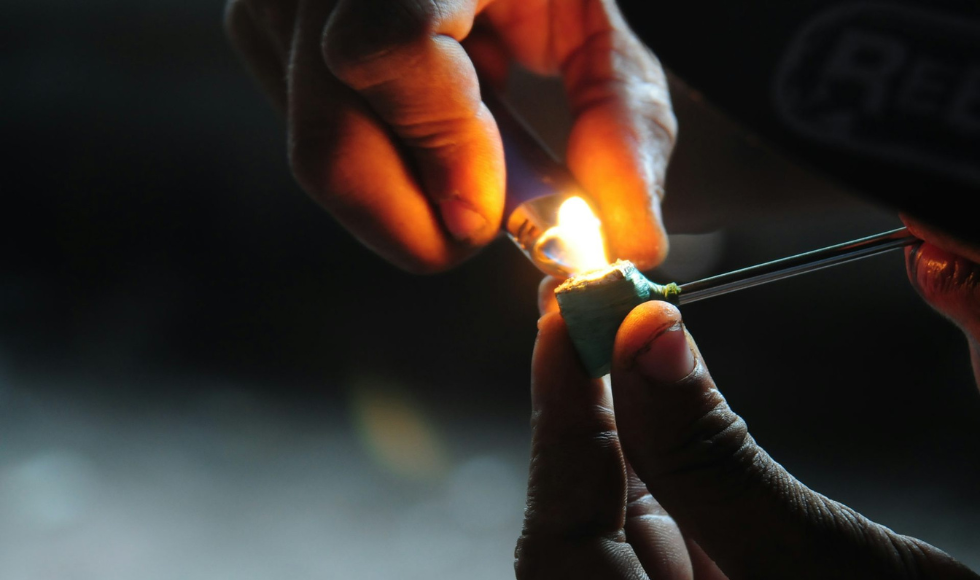 Closeup of hands lighting a drug pipe