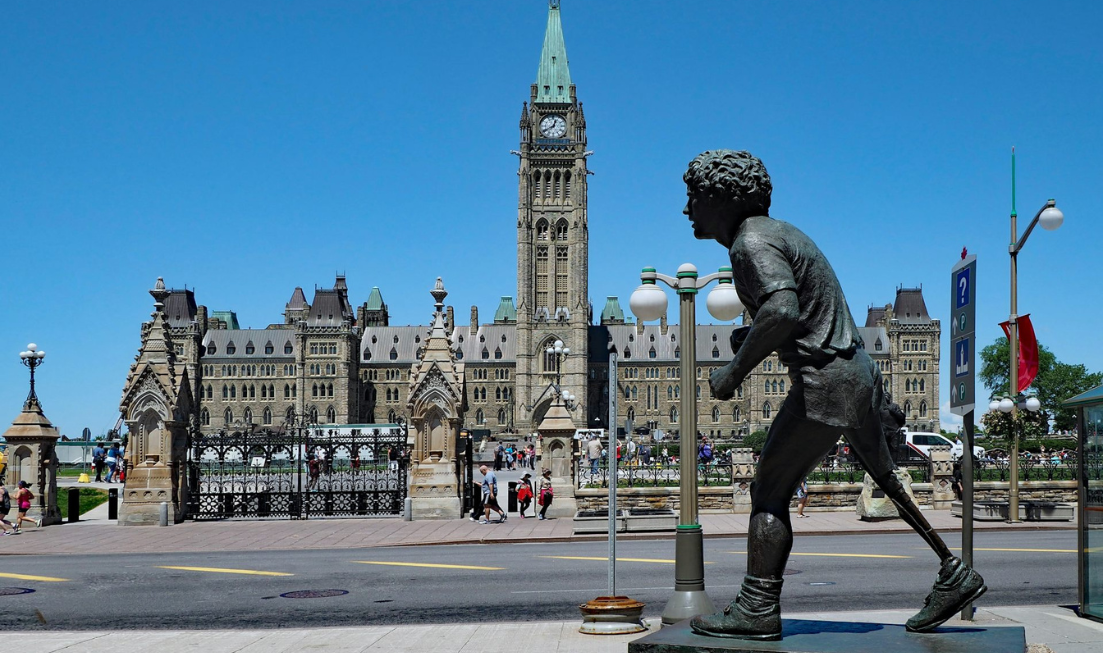 Ottawa's statue of Terry Fox in the foreground, with the Peace Tower and Parliament buildings in the background.