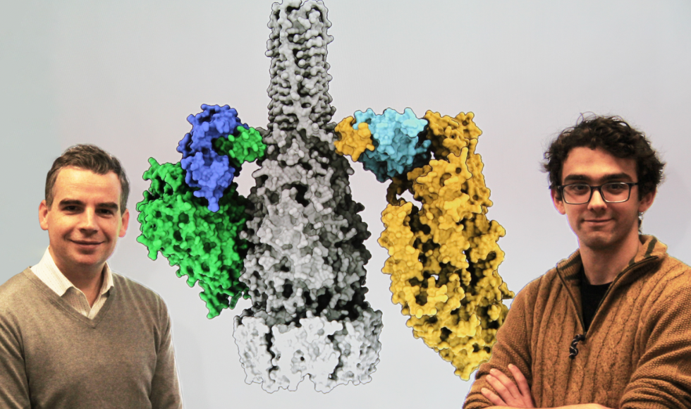 Headshots of John Whitney and Jake Colautti set against a a 3D rendering of a bacterial secretion system