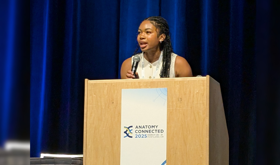 Eva Chima at a podium presenting at the American Association for Anatomy conference.