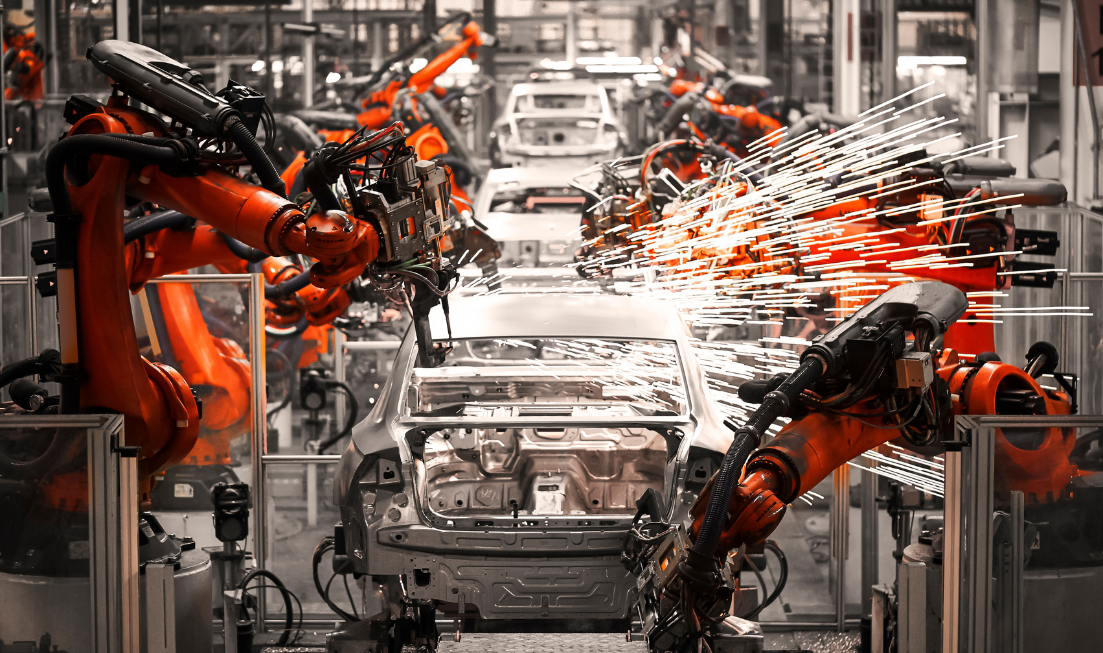 Sparks fly off a vehicle in an assembly line at a production plant.